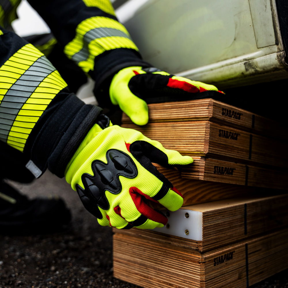 Handschuhe im Einsatz beim Heben von Holz.
