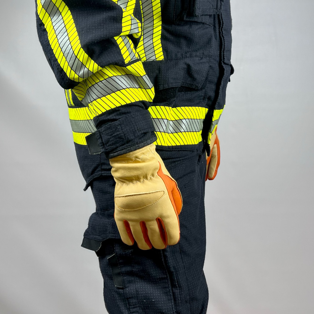 Feuerwehrmann trägt die Penkert Elk Defender 3.0 Kurzvariante Handschuhe, Ansicht von der rechten Seite in einem gelben Feuerwehranzug.