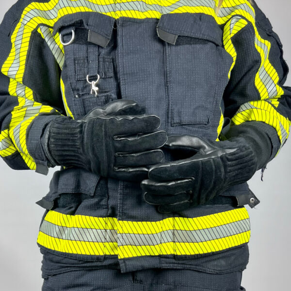 Das Bild zeigt einen Feuerwehrhandschuh "Firegrip 3.0 Short Black" von Penkert, der an den Händen eines Feuerwehrmannes getragen wird. Der Handschuh bietet optimalen Schutz und Haltbarkeit, ideal für den Einsatz in gefährlichen Umgebungen.