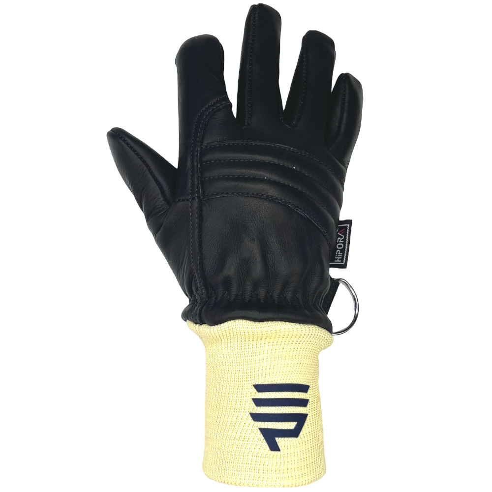 Das Bild zeigt die Rückhand eines schwarzen Feuerwehrhandschuhs mit einer gelben Manschette. Auf der Manschette ist ein blaues Logo aufgedruckt, und der Handschuh verfügt über Verstärkungen auf dem Handrücken für zusätzlichen Schutz. Ein Metallring an der Seite ermöglicht die Befestigung des Handschuhs.