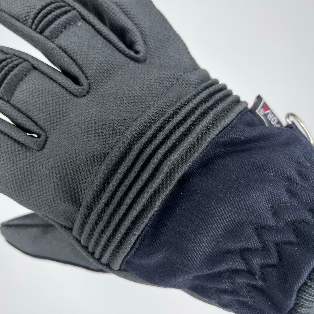 Detailaufnahme des Handrückens eines Schutzhandschuhs mit gepolsterten Knöchelschutz und elastischem Bund für zusätzliche Flexibilität und Schutz.