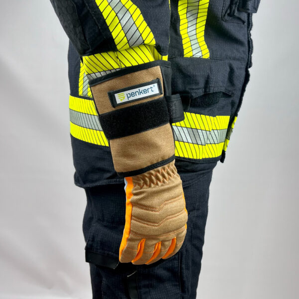 Ein Feuerwehrmann steht mit ausgestrecktem Arm und trägt Penkert HyPA-Grip Handschuhe, wobei die reflektierenden Streifen an der Schutzkleidung und das robuste Design des Handschuhs sichtbar sind.