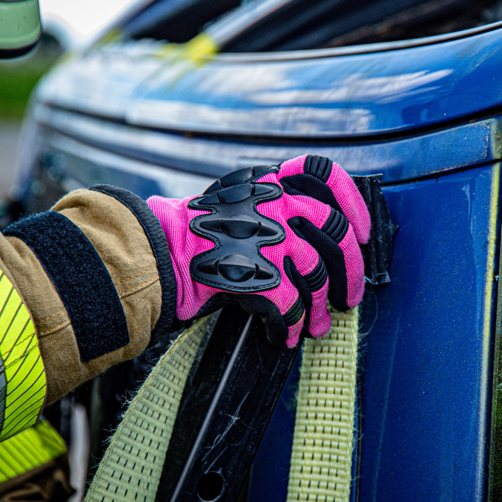Feuerwehrhandschuh Bad Girl 2.0 in Pink im Einsatz beim Sichern eines Autos.